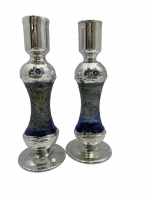 A silver candle holder with glass inside is high